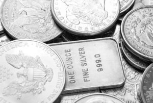 Silver dollar coins piled on a one ounce fine silver 999.0 bar